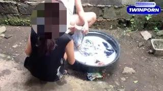 two pinay playing at each other while washing clothes outside